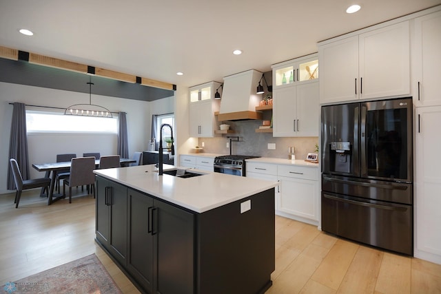 kitchen with tasteful backsplash, premium range hood, gas range, black fridge with ice dispenser, and white cabinetry