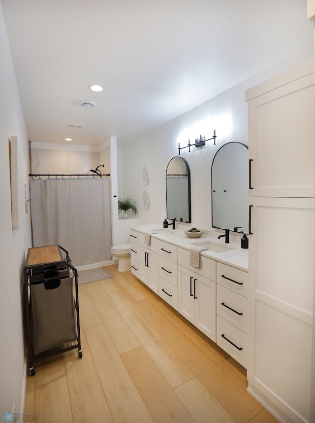 bathroom featuring toilet, hardwood / wood-style floors, and double vanity