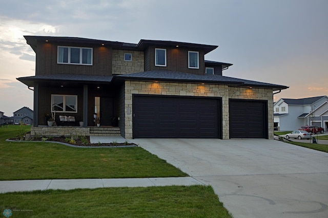 view of front of home with a garage and a lawn