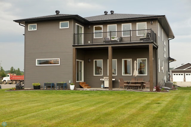 rear view of house featuring a garage, a balcony, central AC, and a lawn