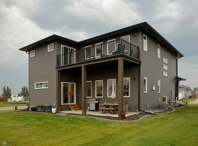 rear view of house with cooling unit, a balcony, a patio area, and a lawn