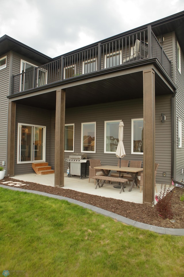 back of house featuring a patio, a balcony, and a lawn