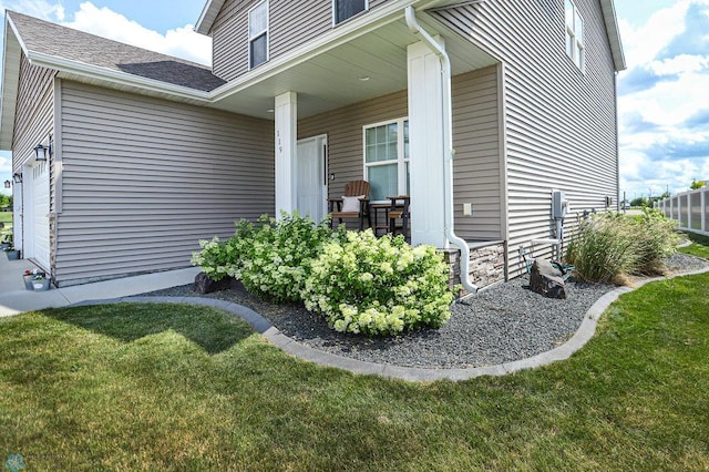 view of side of home featuring a garage and a yard