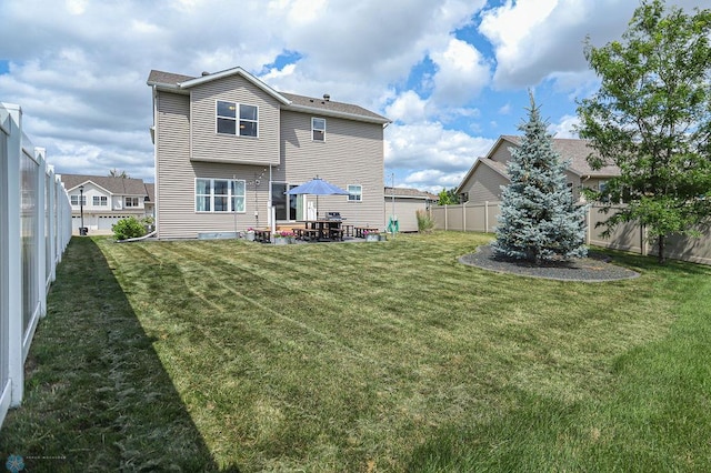 back of house featuring a patio and a lawn