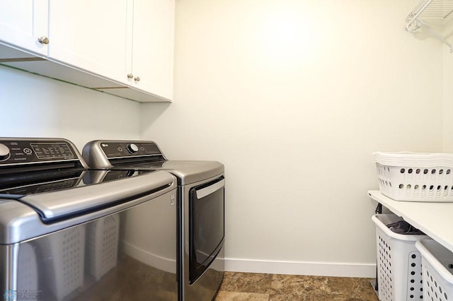 washroom featuring washer and clothes dryer, cabinets, and tile patterned floors