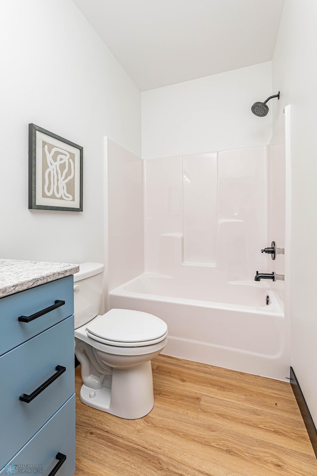 full bathroom with wood-type flooring,  shower combination, vanity, and toilet