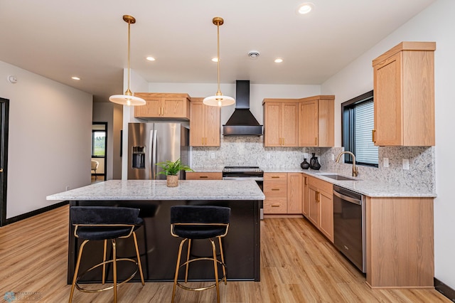 kitchen with appliances with stainless steel finishes, a center island, sink, and wall chimney range hood