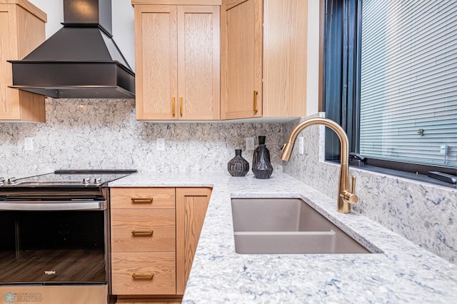 kitchen featuring custom range hood, light stone countertops, light brown cabinets, sink, and stainless steel range with electric cooktop