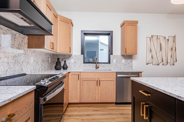 kitchen featuring appliances with stainless steel finishes, backsplash, light stone countertops, light hardwood / wood-style flooring, and sink