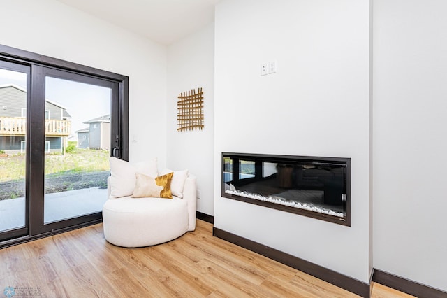 sitting room with hardwood / wood-style flooring and a healthy amount of sunlight