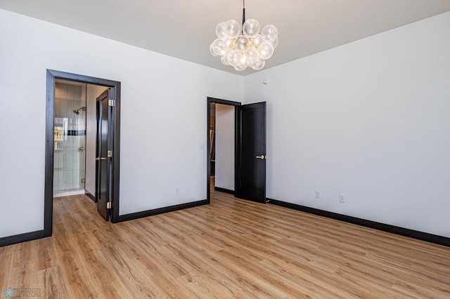 unfurnished bedroom with a notable chandelier and light wood-type flooring