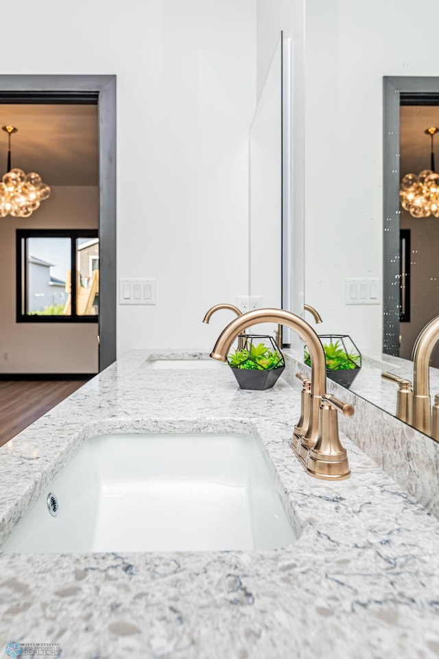 details with vanity, a chandelier, and hardwood / wood-style floors