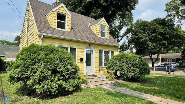 new england style home featuring a front lawn