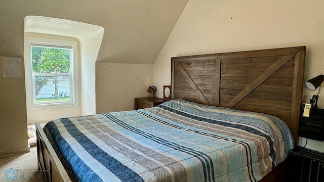 bedroom featuring lofted ceiling and carpet