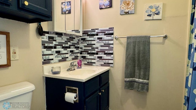 bathroom featuring decorative backsplash, toilet, and vanity