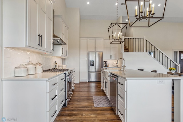 kitchen featuring a center island with sink, decorative backsplash, high quality appliances, dark hardwood / wood-style flooring, and a towering ceiling