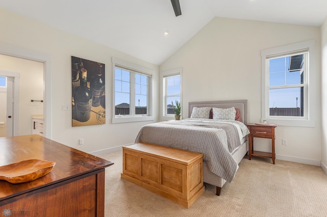 bedroom with lofted ceiling, connected bathroom, light colored carpet, and ceiling fan