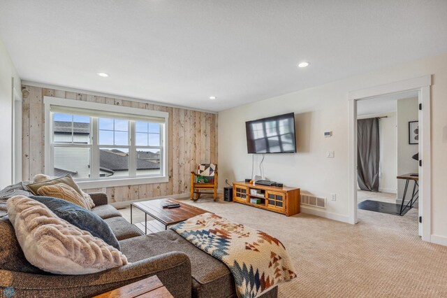 carpeted living room with wood walls