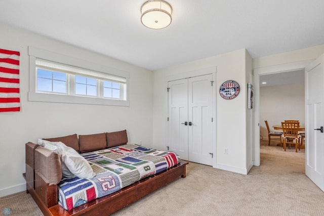 bedroom with a closet and light colored carpet