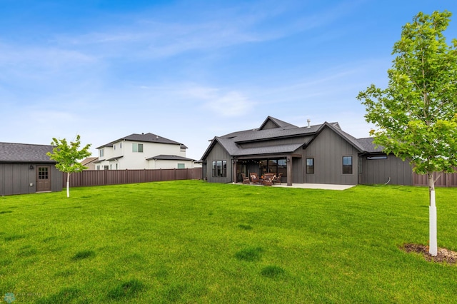 back of house with a patio and a yard