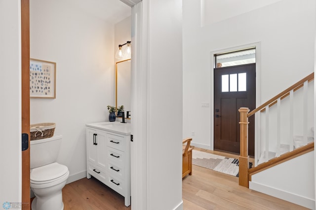 bathroom with wood-type flooring, toilet, and vanity