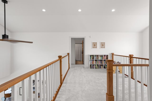 corridor with light carpet and vaulted ceiling