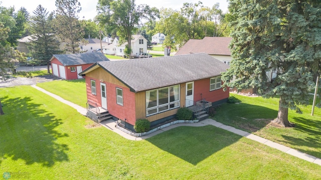 view of front of property with a storage unit and a front lawn