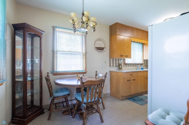 tiled dining room featuring sink and a chandelier