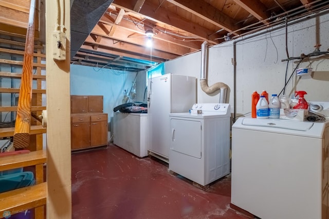 basement featuring white refrigerator and washing machine and dryer