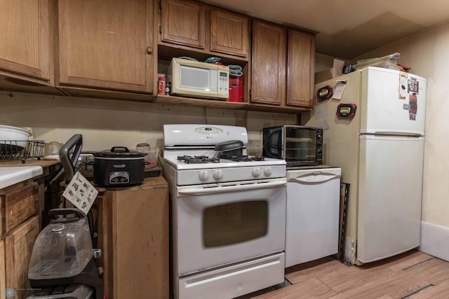 kitchen with light hardwood / wood-style flooring and white appliances