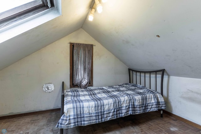 bedroom featuring lofted ceiling and parquet flooring