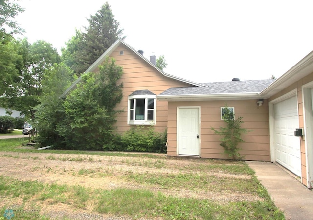 exterior space with a garage and a lawn