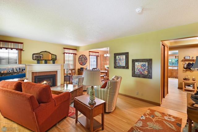 living room featuring a textured ceiling, light hardwood / wood-style flooring, and a fireplace