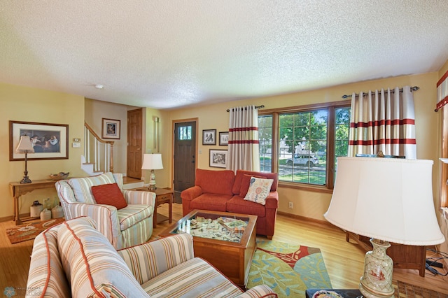 living room with light wood-type flooring and a textured ceiling