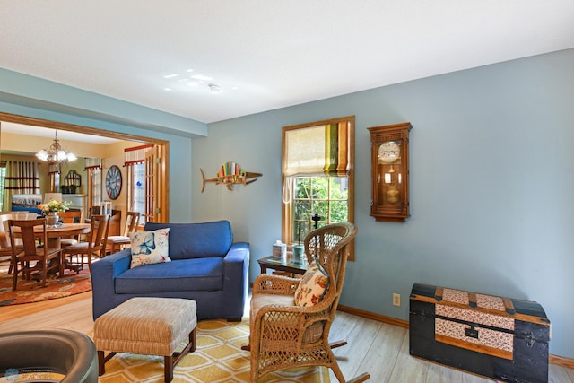 living room with an inviting chandelier and light hardwood / wood-style floors