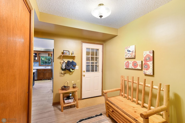 hallway featuring a textured ceiling and light hardwood / wood-style floors