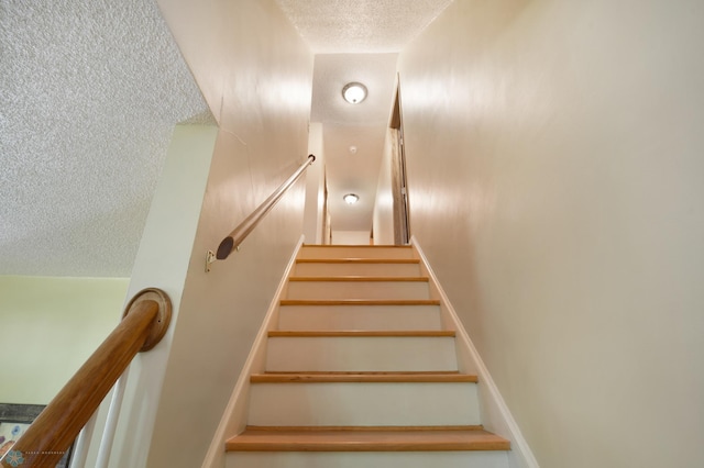 staircase with a textured ceiling