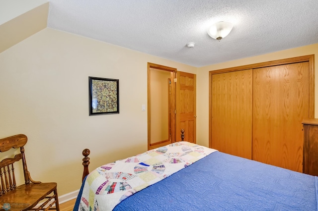 bedroom featuring hardwood / wood-style flooring, a closet, and a textured ceiling