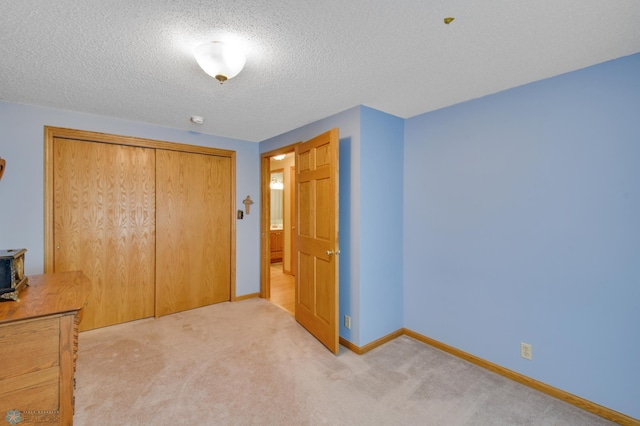 unfurnished bedroom with a closet, light colored carpet, and a textured ceiling