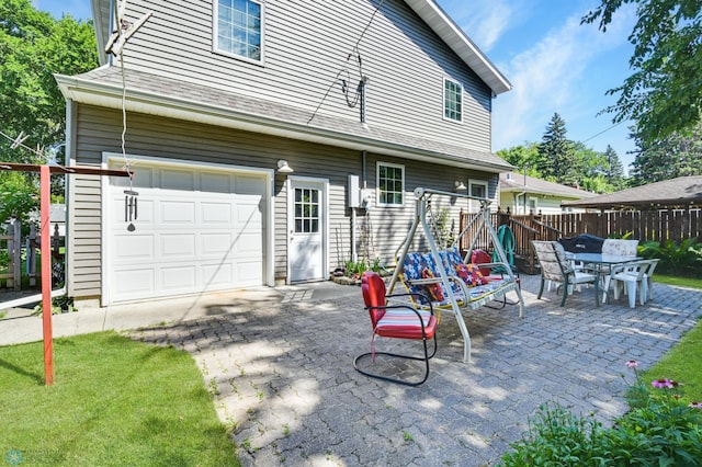 rear view of property featuring a lawn and a garage