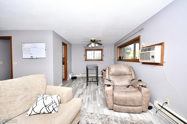 living room featuring ceiling fan, light wood-type flooring, baseboard heating, and a textured ceiling