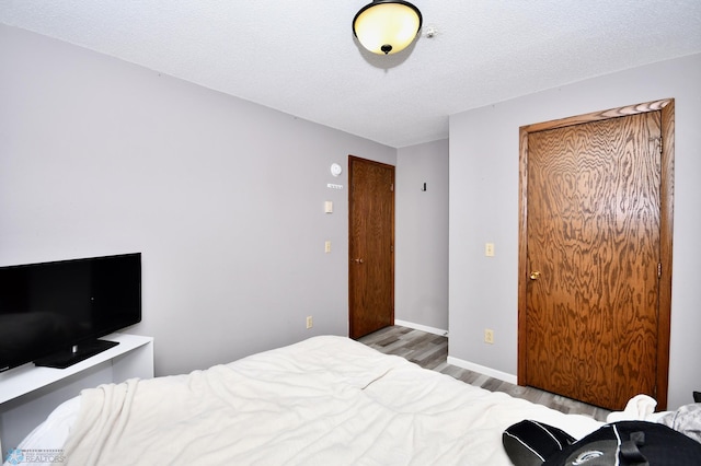 bedroom featuring a textured ceiling and hardwood / wood-style floors