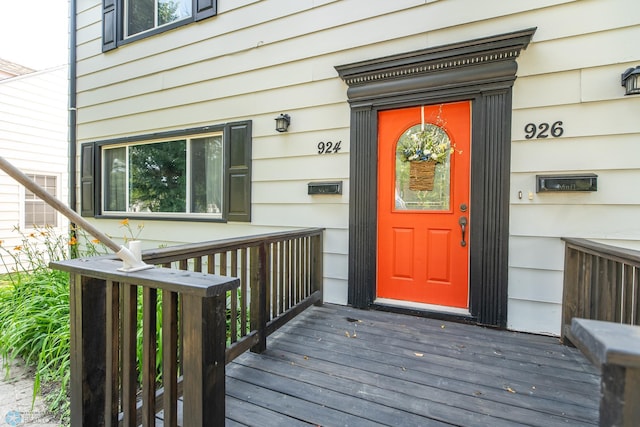 view of exterior entry featuring a wooden deck