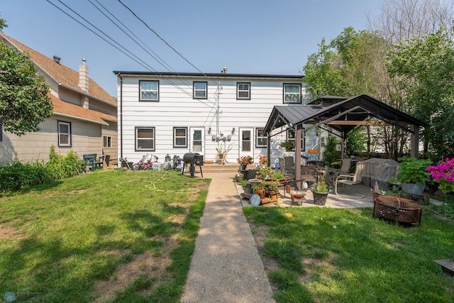 rear view of house with a lawn, a patio area, a gazebo, and an outdoor fire pit