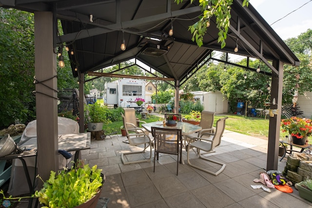 view of patio featuring a gazebo and a shed