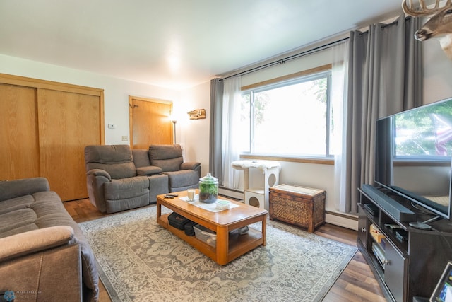 living room featuring a baseboard heating unit and hardwood / wood-style floors