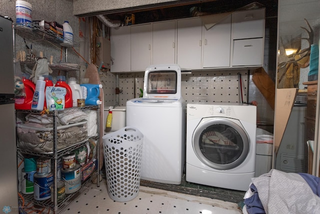 washroom featuring washing machine and dryer and cabinets