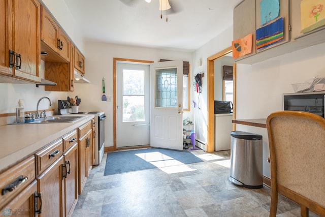 kitchen with white stove, sink, washer / clothes dryer, light tile patterned flooring, and ceiling fan