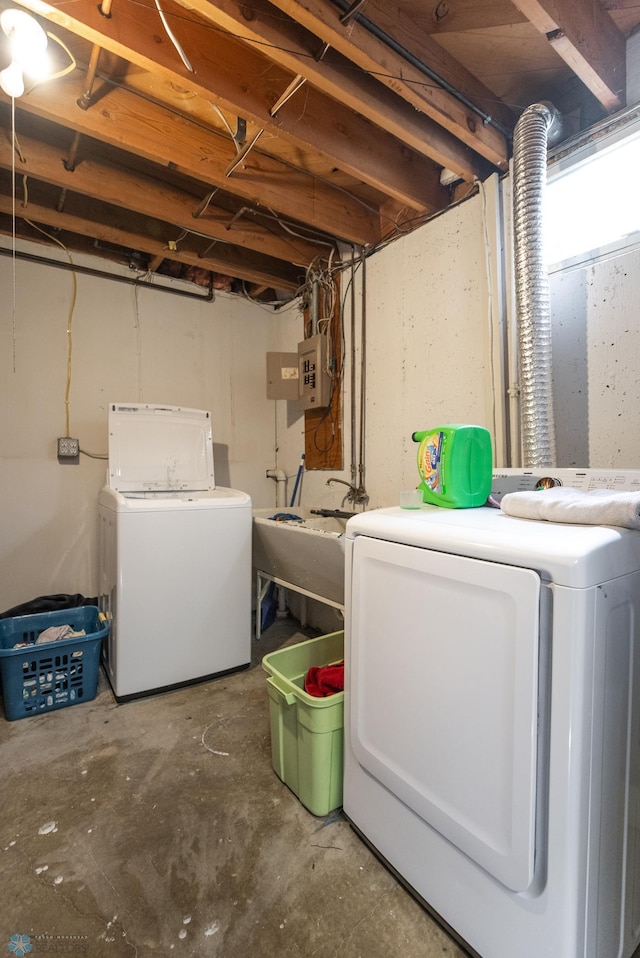 laundry area featuring sink, washing machine and dryer, and electric panel