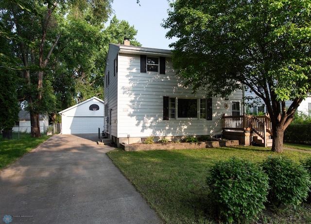 view of front of house featuring a garage, an outdoor structure, and a front yard